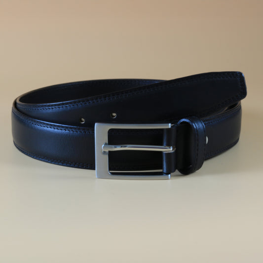 Black leather belt with a silver buckle on a beige background