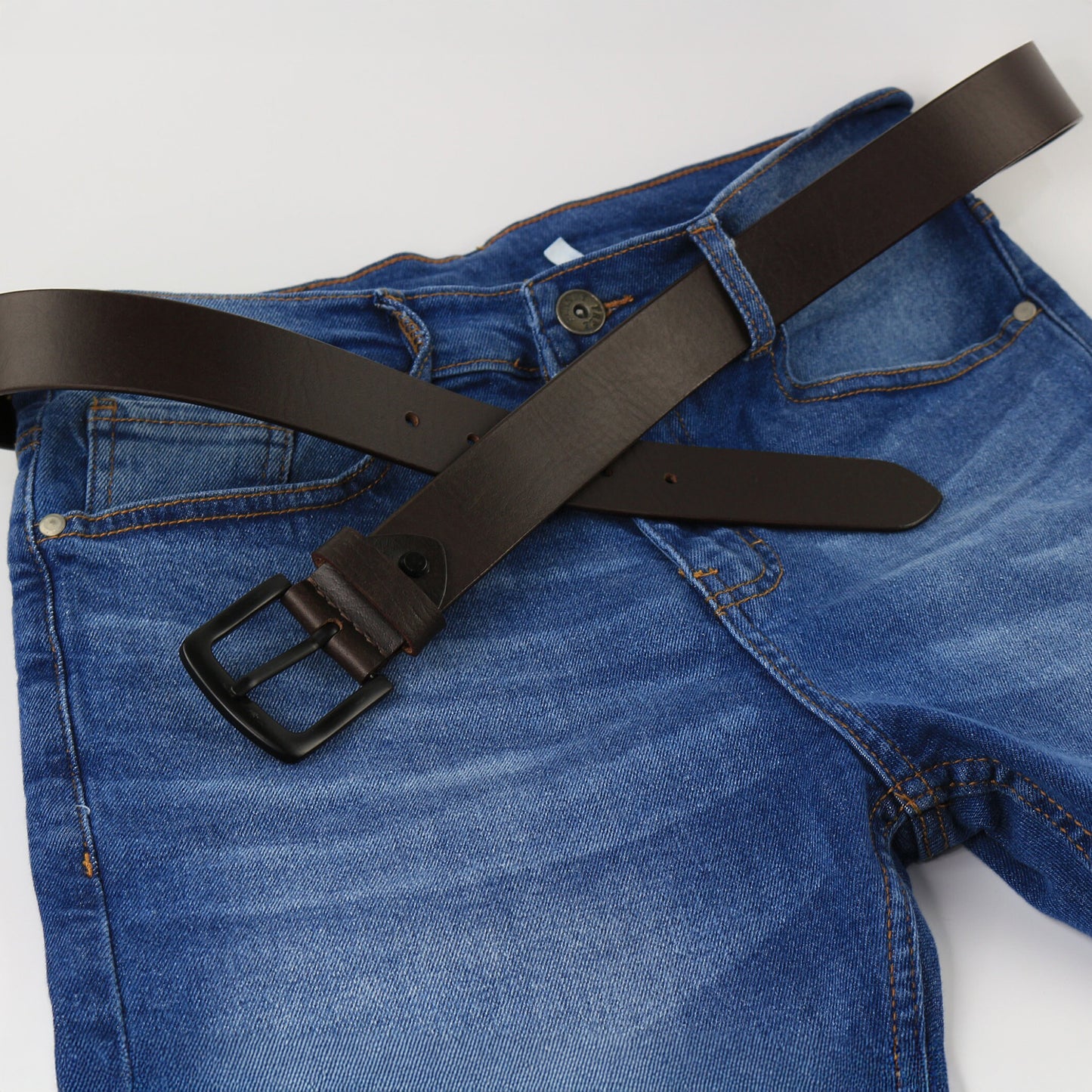 Blue jeans with a black belt on a white background