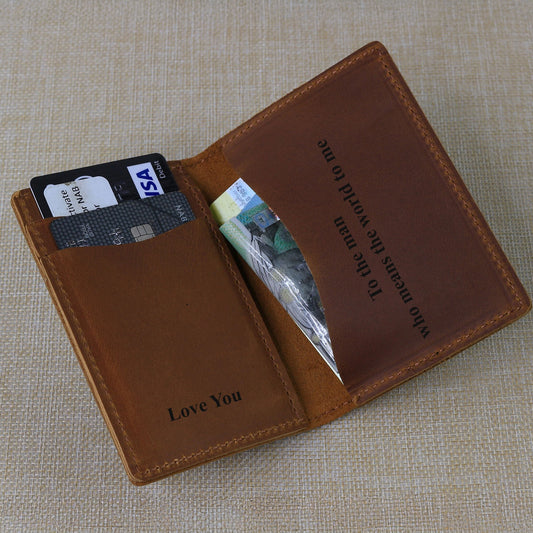 Custom Bifold Brown engraved leather card wallet with cards and money on a beige fabric background
