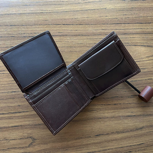 Open brown leather wallet on a wooden surface