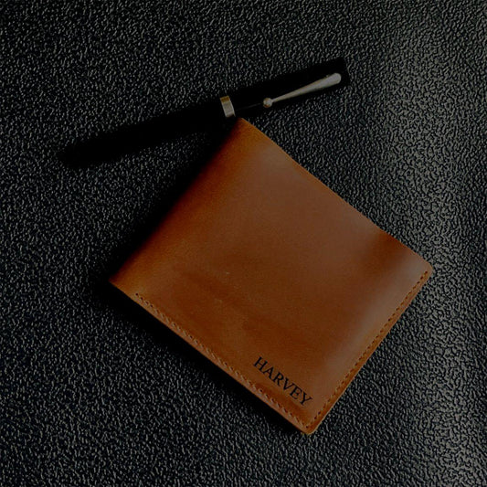 Brown leather wallet with 'Harvey' branding on a dark textured surface
