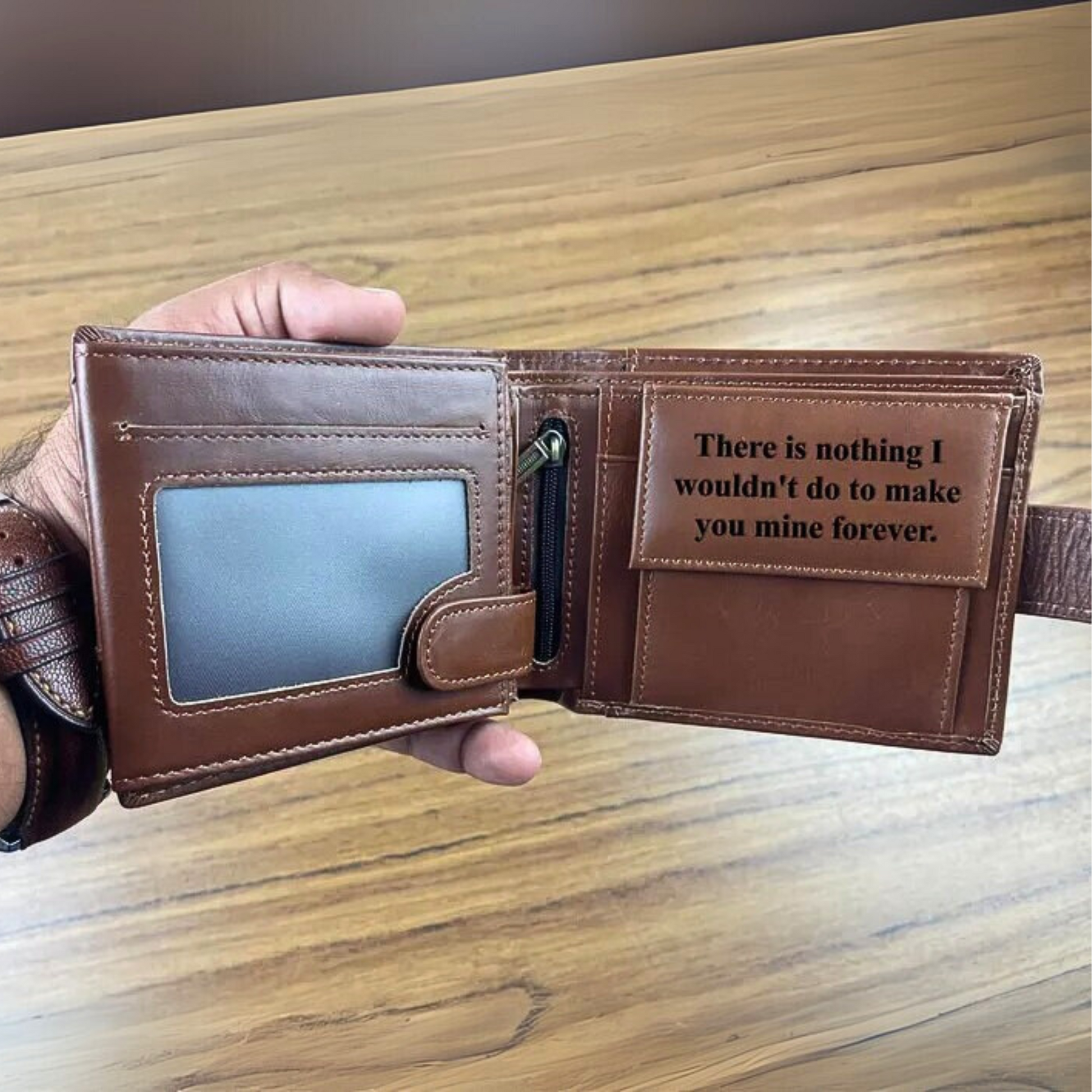 Personalised Brown leather wallet with engraved message on a wooden surface