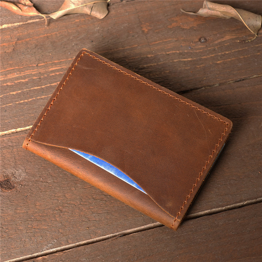 Minimalist slim leather card holder in vintage brown, featuring a quick-access front pocket and handcrafted rugged stitching on a wooden background.