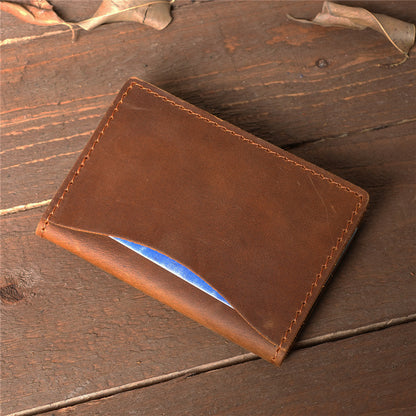 Minimalist slim leather card holder in vintage brown, featuring a quick-access front pocket and handcrafted rugged stitching on a wooden background.