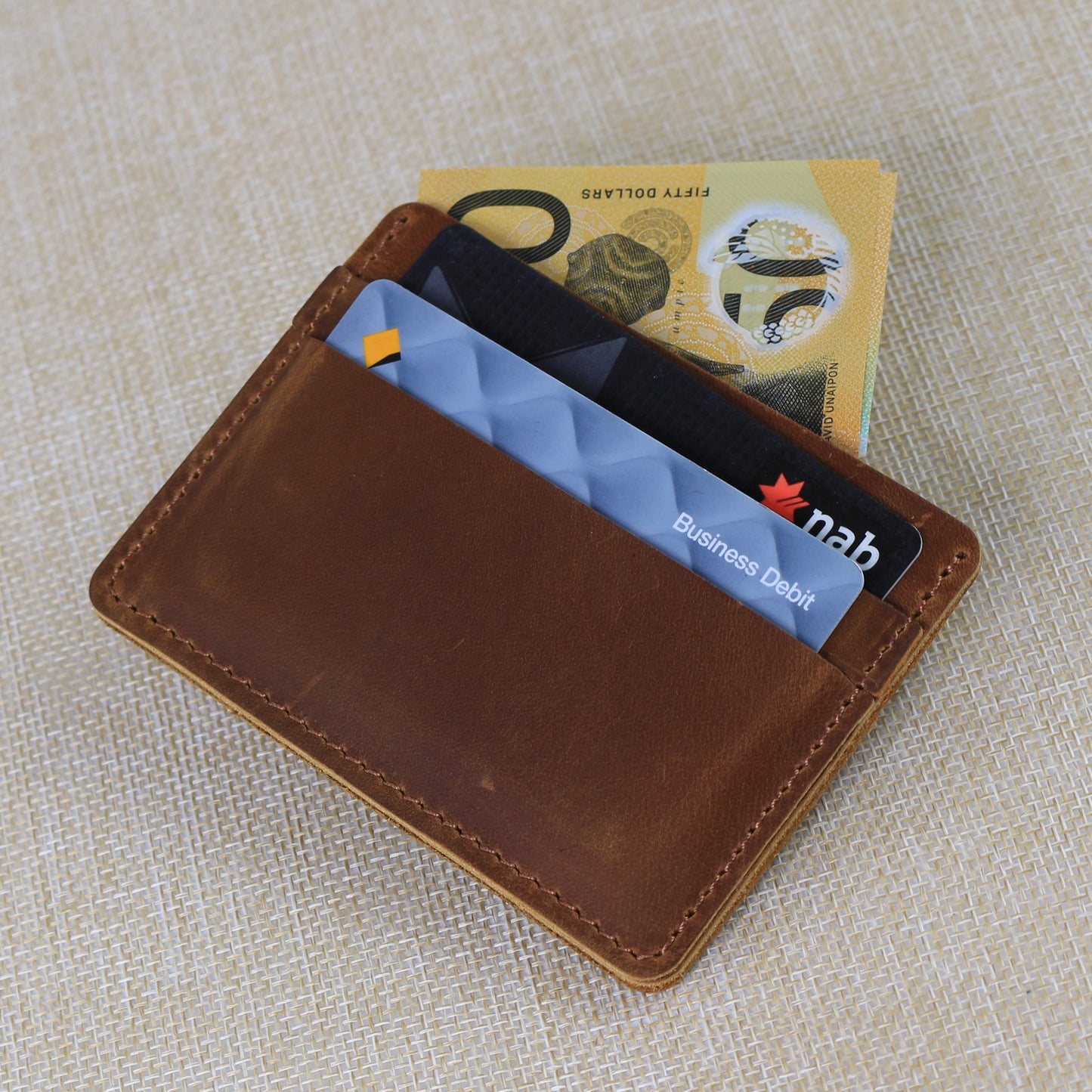 Interior view of a premium leather wallet showing tiered card slots and a secure zippered coin pocket with durable contrast stitching.