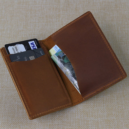 Custom engraved men's leather wallet interior displaying personalized text, bank cards, and cash, highlighting the compact bifold design.