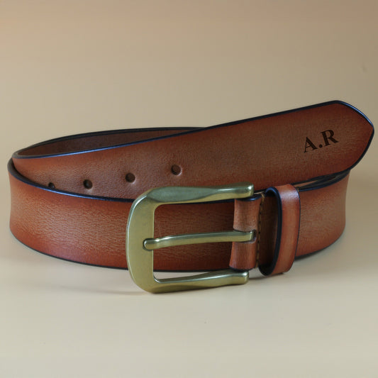 Brown leather belt with brass buckle on a beige background