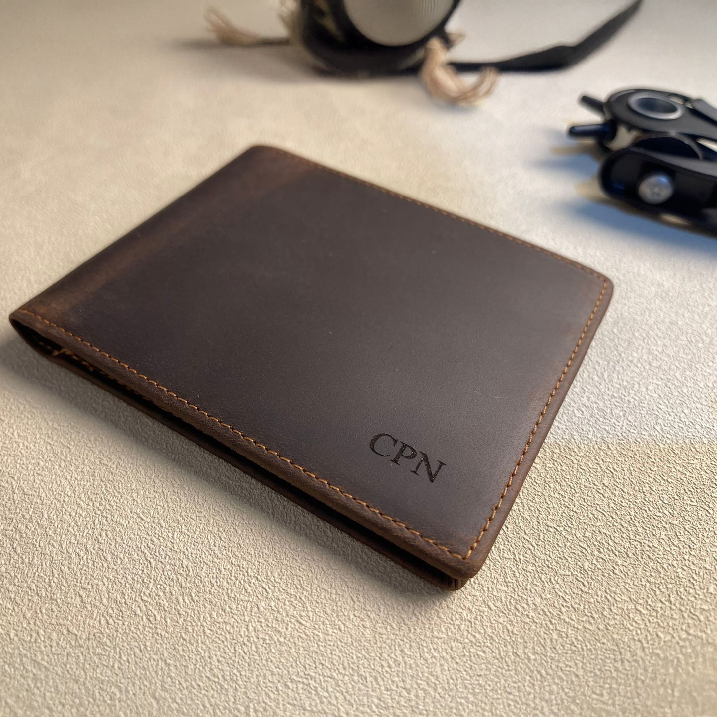 Brown leather wallet with 'CPN' initials on a light surface