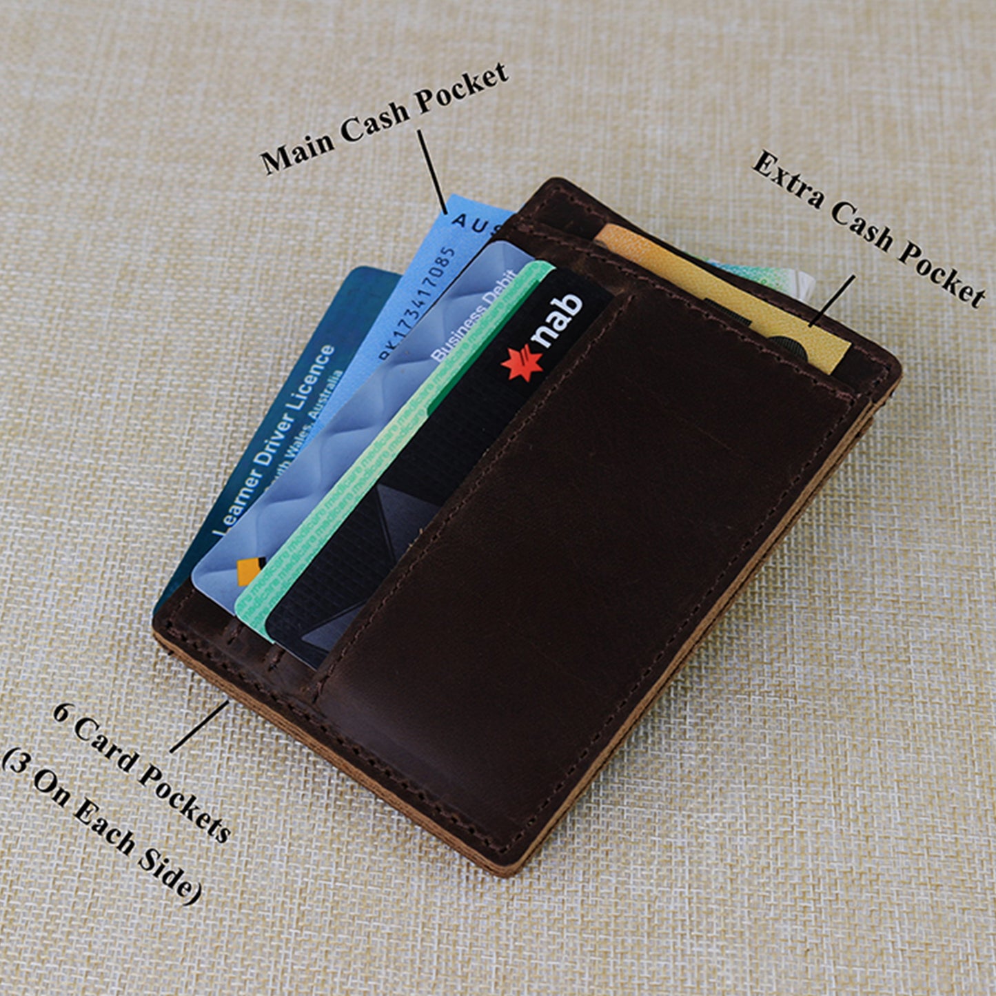 Handcrafted tan leather accessory set including a slim card wallet with tiered slots and a matching leather key fob on a rustic wooden background.