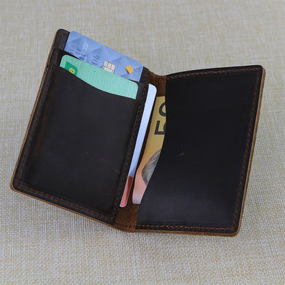 Open trifold custom leather card wallet with cards and money on a textured fabric background
