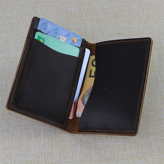 Open trifold custom leather card wallet with cards and money on a textured fabric background