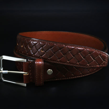 Brown woven leather belt with a silver buckle on a black background