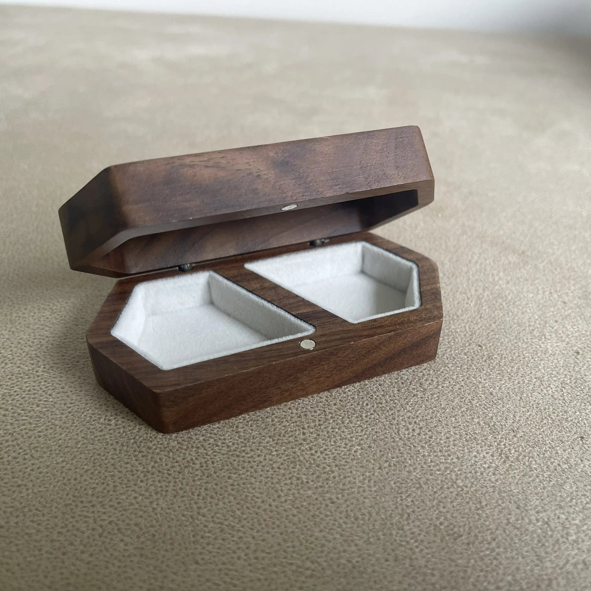 Dark walnut wooden double ring box with two white ring compartments photographed open on a clean light grey background.