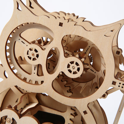 Close-up of a wooden mechanical model with interlocking gears on a white background