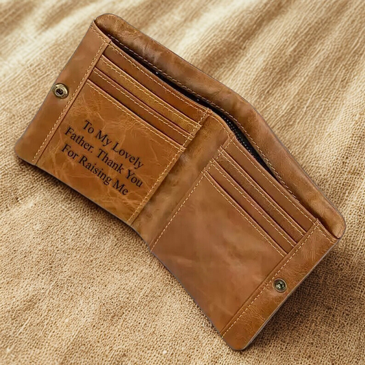 Light brown leather wallet with engraved message on a beige fabric background