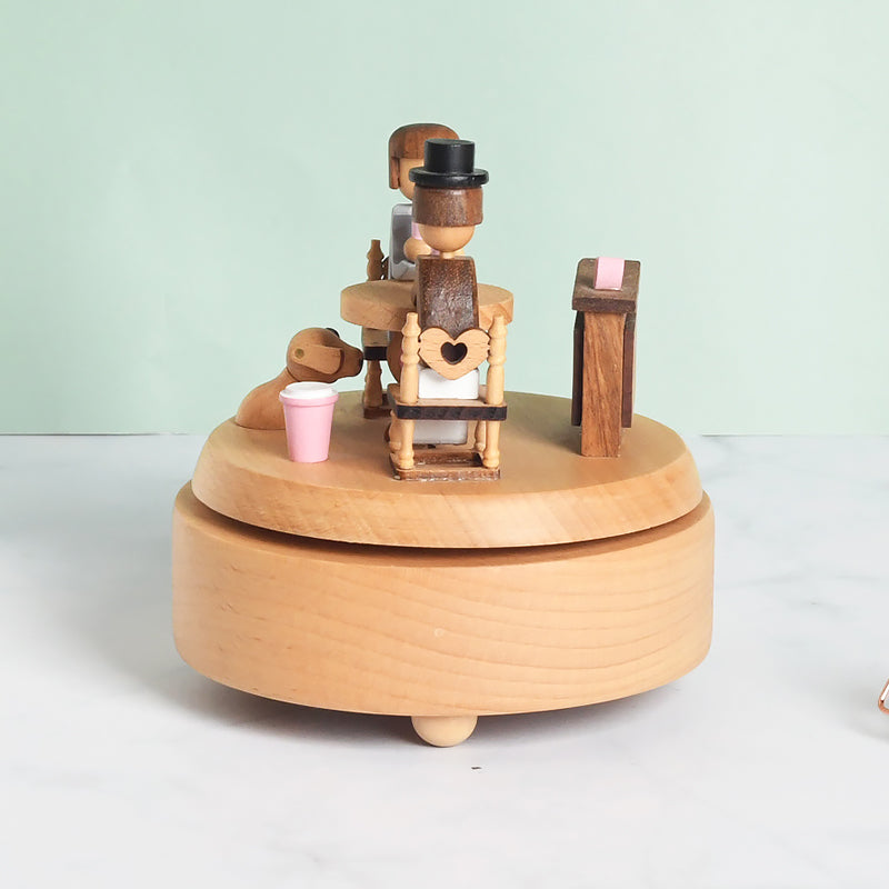 Wooden music box with mechanical figures on a light green background