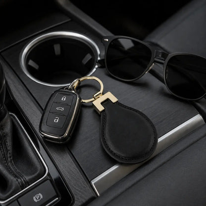 Black leather keychain with car keys and sunglasses displayed inside vehicle centre console