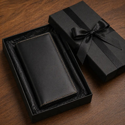 Slim black leather bifold long wallet featuring a smooth grain finish and detailed edge stitching, gift-ready in a black presentation box.