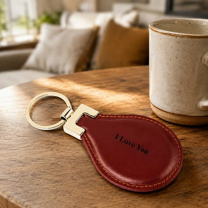 Personalised brown leather keychain engraved with I Love You styled beside coffee in a warm home setting
