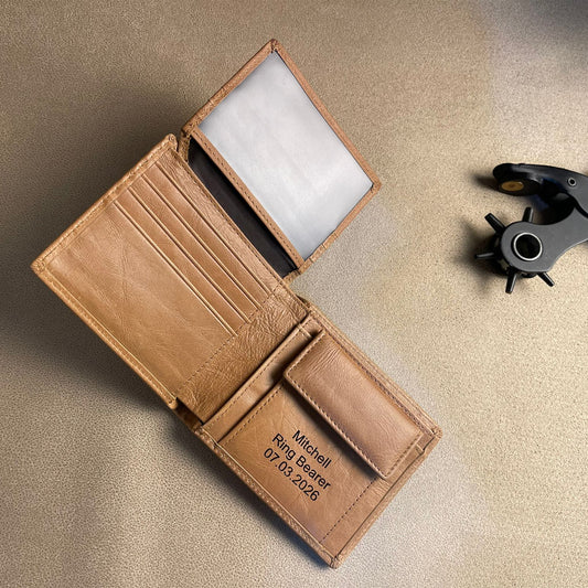 Brown leather wallet with engraved text on a beige surface