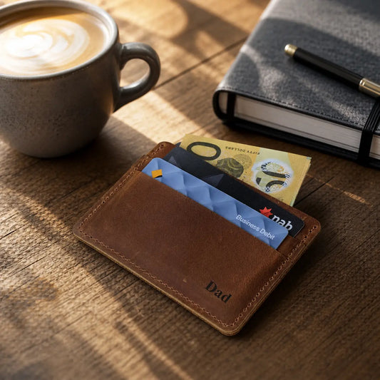 Close-up view of an open handcrafted brown leather slim wallet featuring durable perimeter stitching and multiple vertical card pockets holding bank cards.