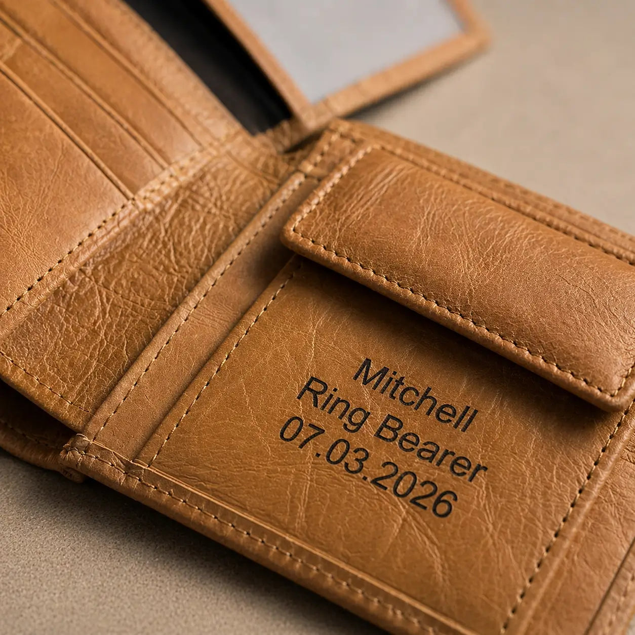 High-quality tan leather trifold wallet interior highlighting the smooth grain texture, snap coin compartment, and personalized laser engraving.