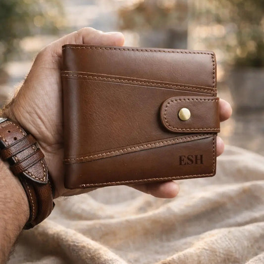 Custom engraved men's brown leather wallet with initials, handcrafted bifold design with secure tab, personalized gift for him shown in a lifestyle setting.