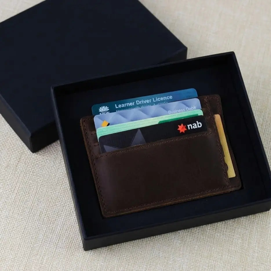 Handcrafted tan grain leather slim card wallet featuring a custom engraved "DAD" message, presented in a luxury black packaging box.