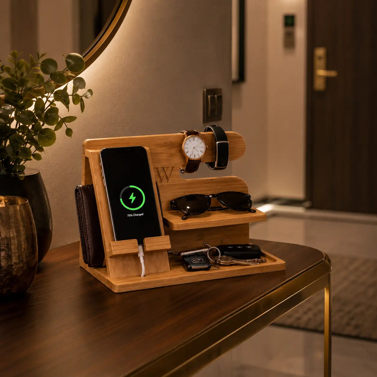 Elegant bamboo docking station organizer displayed on a luxury hallway console table with smartphone charging, wristwatch, fitness band, sunglasses, wallet and car keys arranged neatly under warm ambient entryway lighting.
