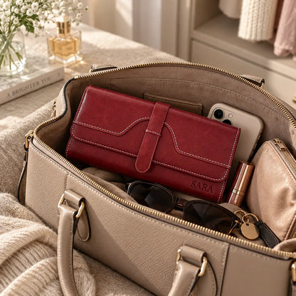 Personalised red women’s wallet engraved with SARA inside beige handbag with phone, sunglasses and accessories