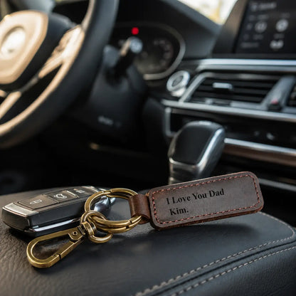 Personalised brown leather keychain attached to car keys and displayed on a vehicle seat