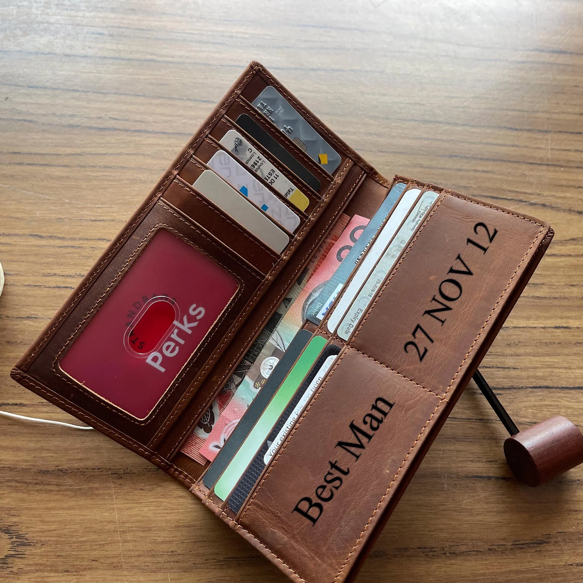 Handcrafted light brown leather trifold wallet for men, featuring high-capacity organized storage and durable metal hardware, presented on a rustic burlap surface.