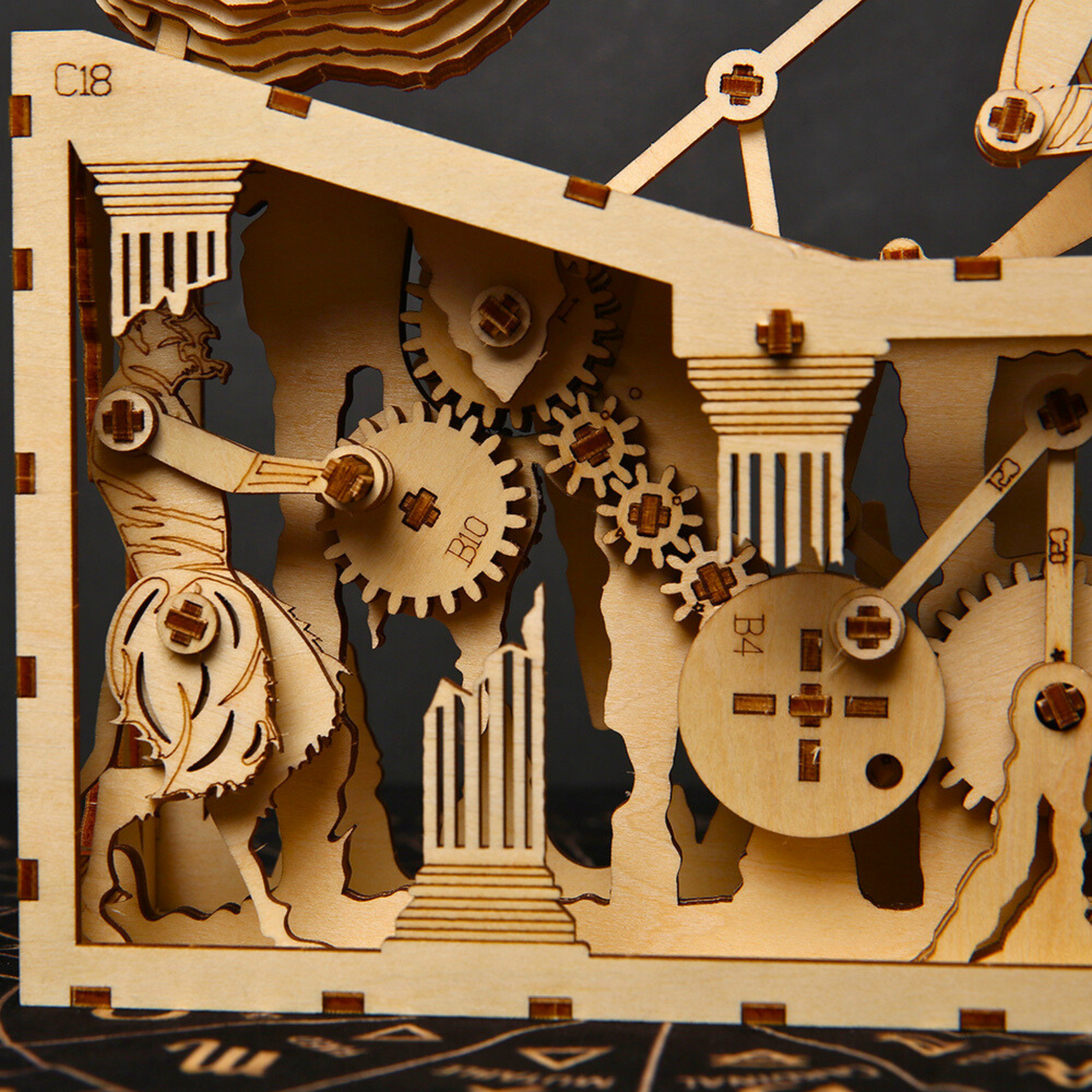 Wooden mechanical puzzle with close view of gears and a figure on a dark background