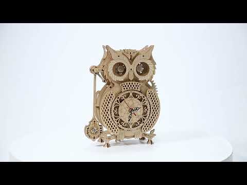 Wooden clock model of owl puzzle with mechanical design and gears against a white background