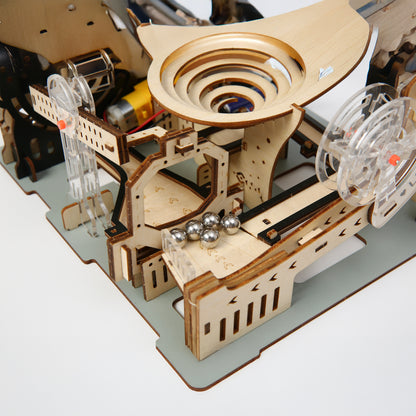 Wooden mechanical model with gears and balls on a white background