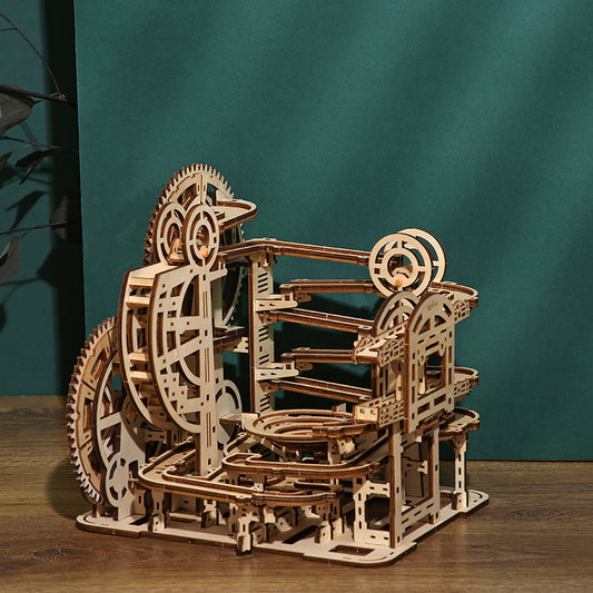 Wooden marble run game puzzle on a wooden surface with a teal background