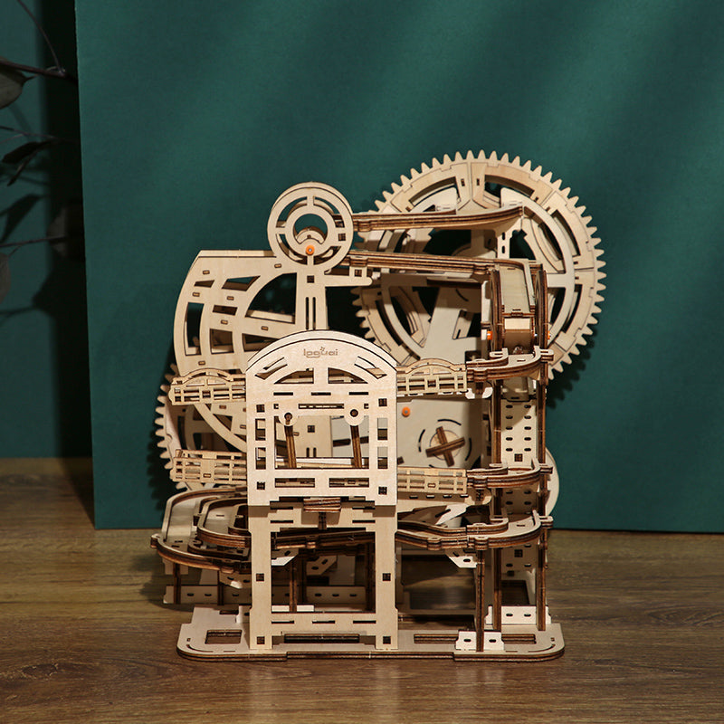 Wooden marble run game puzzle  with gears on a wooden surface against a teal background