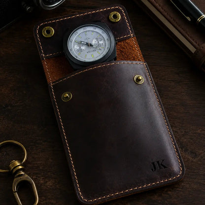 Moody close-up of a personalized dark brown leather watch pouch showcasing detailed stitching, brass snap buttons, and rich leather texture with a luxury craftsmanship aesthetic and partially visible watch.