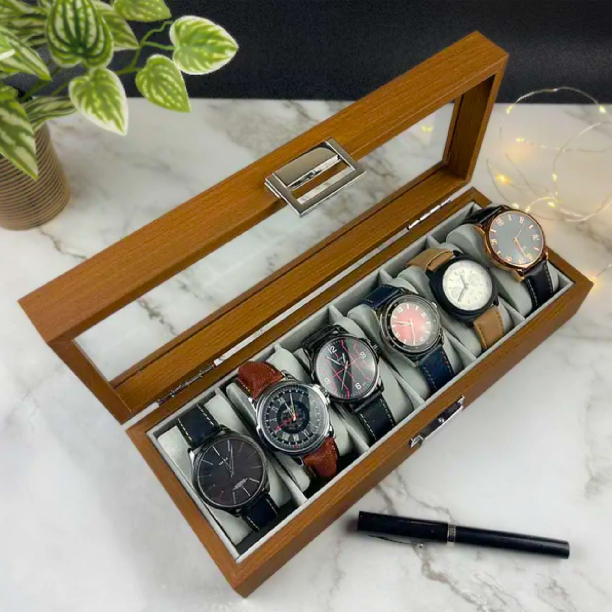 Wooden watch box with six watches, used to organized and beautifully showcasing timepieces.