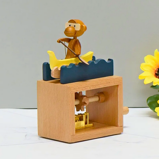 A wooden music box toy with a monkey rowing a yellow boat on blue waves, designed as a playful decorative piece.
