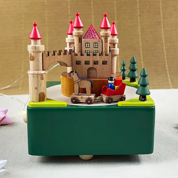A wooden castle music box toy with red-roofed towers, a horse-drawn cart, and miniature trees, crafted as a charming decorative item.